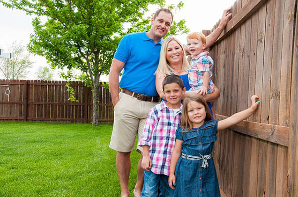 happy family stands by the fence