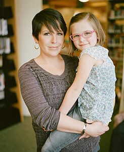 woman holds a girl in her arms